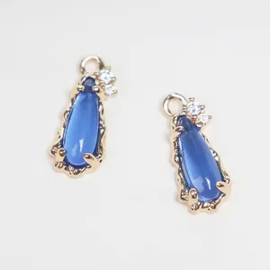 Detail shot of blue teardrop glass pendants with copper gold plating and zircon accents
