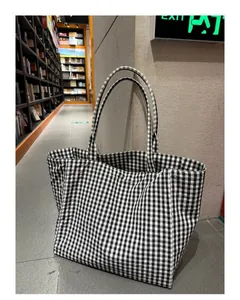 Large capacity black and white gingham tote bag in a library setting for daily use