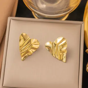 Close-up of golden irregular heart-shaped earrings with unique wrinkled texture