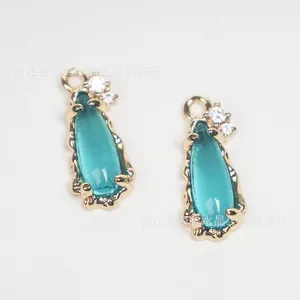 Detailed macro view of teal waterdrop glass pendant with copper-inlaid zircon accents