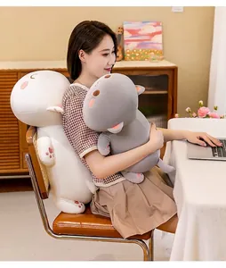 Soft long cat plush pillow used as lumbar support while working on a laptop at a desk