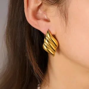 Close-up view of elegant gold irregular oval stainless steel earrings worn by a model