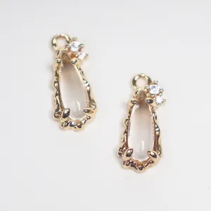 Close-up of teardrop glass pendants with golden zircon copper border for DIY jewelry