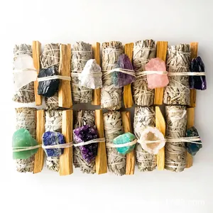 Detailed view of bundled white sage, palo santo sticks, and various natural crystals