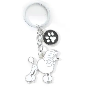 Detail of a white poodle dog keychain made of zinc alloy with paw print charm