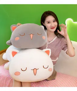 Close-up detail of large grey and white cat plush pillows being held by a female model