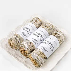Three natural California white sage smudge sticks on a white ceramic decorative plate