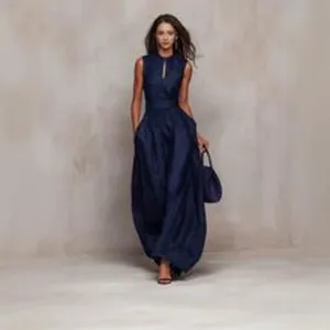 Elegant model posing in a navy blue sleeveless maxi dress with a stylish cutout detail