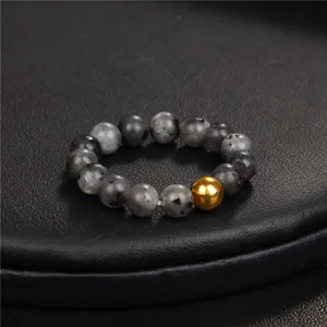 Close-up of natural stone beaded ring featuring grey marble beads and a gold metal accent
