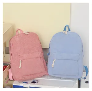 Detailed view of pink and blue corduroy backpacks highlighting soft ribbed texture.