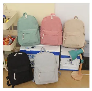 Detailed view of colorful corduroy student backpacks in a cozy dormitory room setting