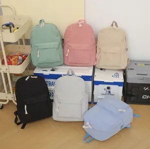 Collection of various colored corduroy backpacks displayed in a cozy indoor lifestyle setting