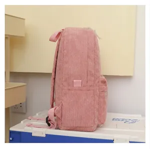 Side view of a pink corduroy backpack showing textured fabric and side pocket detail