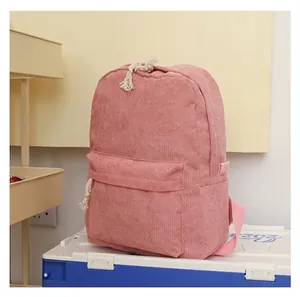 Detailed side view of pink corduroy backpack showing textured fabric and front pocket