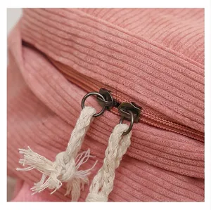 Close-up of pink corduroy backpack detail showing double zipper with rope pulls