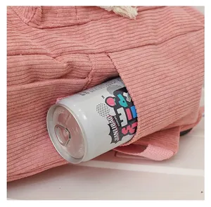 Close-up detail of a pink corduroy backpack side pocket holding a standard soda can.