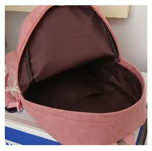 Close-up of pink corduroy backpack showing spacious brown inner lining and zipper
