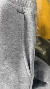 Gros plan sur la poche et la taille d'un pantalon de jogging gris avec détails de couture