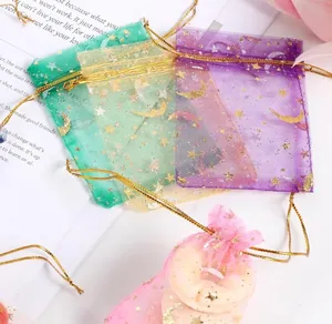 Close-up of organza drawstring bags with gold moon and star patterns for gift packaging