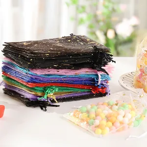 Macro detail showing gold star and moon foil stamping on colorful organza drawstring bags