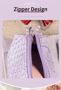 Detailed macro view of the gold zipper on a lavender crocodile pattern jewelry pouch bag