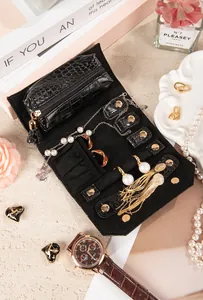 Open portable crocodile pattern jewelry roll organizer with pearls and gold earrings