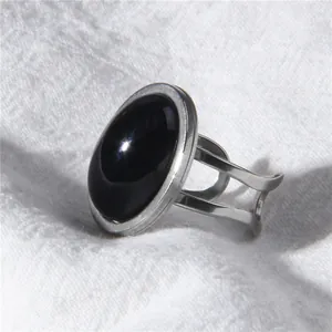 Detailed macro view of a minimalist silver ring with a polished oval black stone