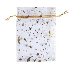 Close-up of a white organza drawstring gift bag with elegant gold star and moon foil prints.