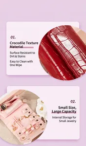 Close-up of crocodile pattern jewelry roll and pink velvet interior with storage slots.