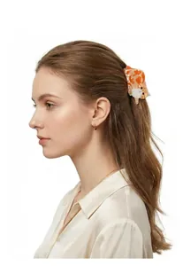 Detailed side view of a cute orange and white cat hair claw clip on model's hair