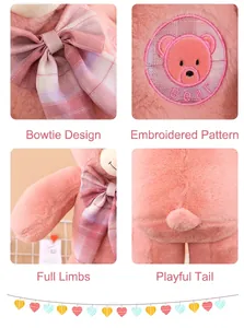 Détails d'un ours en peluche rose avec un nœud papillon à carreaux et un motif brodé