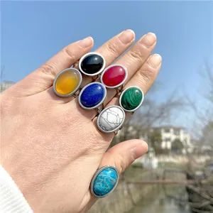 Set of minimalist silver-toned rings featuring colorful oval gemstones on fingers