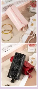 Close-up view of portable crocodile pattern jewelry clutch roll featuring a tassel zipper pull