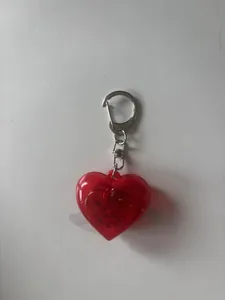 Detailed view of a red heart-shaped LED glowing keychain with metallic ring