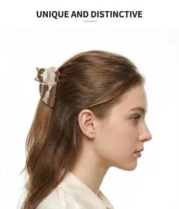 Side profile view of a woman wearing a cute cat-shaped acetate hair claw clip in brown