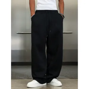Pantalon de jogging noir ample pour hommes avec jambe large et taille à cordon serrage.