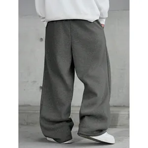 Vue arrière d'un pantalon de jogging ample gris foncé pour homme dans un décor industriel