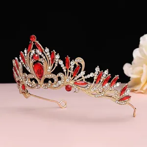 Gros plan détaillé d'une luxueuse couronne de mariée dorée sertie de cristaux rouges.