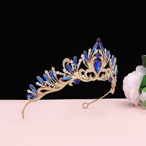 Gros plan d'un diadème de mariée doré avec cristaux bleu roi et strass brillants.