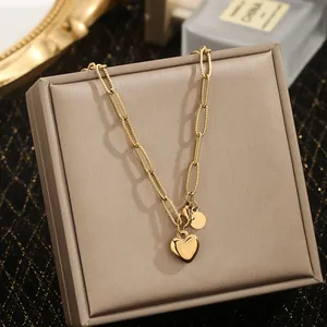 Close-up detail of a golden stainless steel heart pendant necklace on a jewelry box.