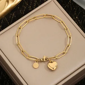 Close-up of golden stainless steel paperclip chain bracelet with heart pendant