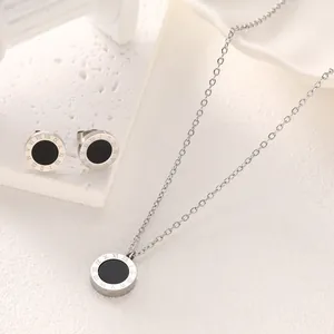 Elegant titanium steel jewelry set featuring a black pendant and Roman numeral engravings.