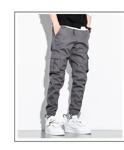 Detail view of gray cotton cargo pants with side pockets and elastic jogger cuffs.