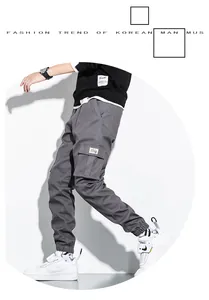 Detail view of men's grey multi-pocket cotton cargo pants with a stylish cuffed hem