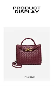 Vista macro dettagliata di una borsa in pelle intrecciata bordeaux con fiocco oro.