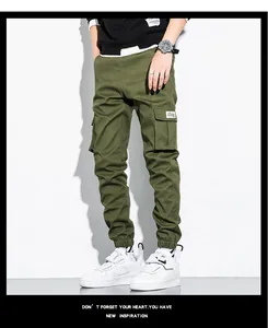 Close-up of olive green men's cotton cargo pants with side pockets and elastic cuffs