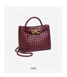Vista laterale dettagliata della borsa tote in pelle intrecciata bordeaux con fiocco d'oro
