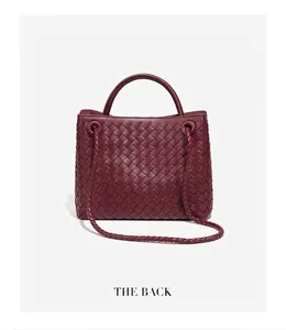 Vista posteriore dettagliata di una borsa tote in pelle bordeaux intrecciata a mano