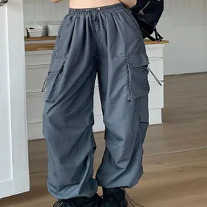 Detail of grey nylon parachute cargo pants with drawstring pockets and wide leg fit