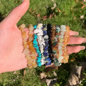 Primo piano di vari braccialetti elastici in pietre di cristallo naturale in mano